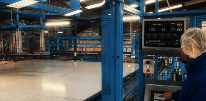 Operator controlling an industrial liner production machine via a touchscreen interface