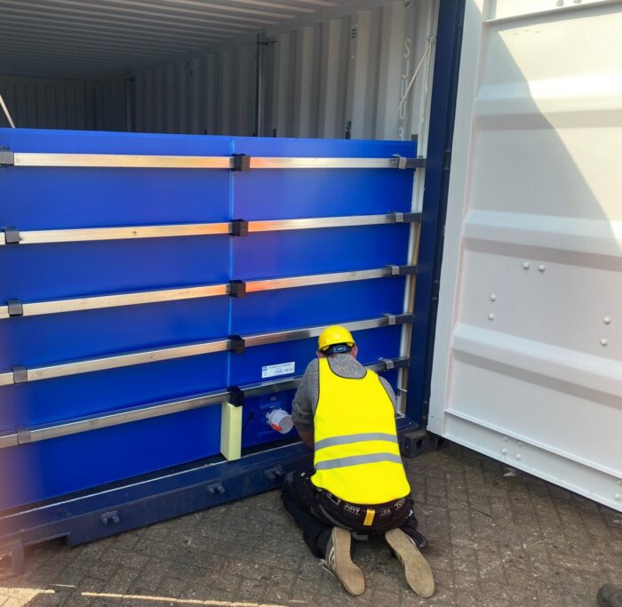 Operator installing a bulkhead for a Flexitank in a shipping container